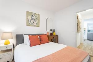 a white bed with orange pillows in a bedroom at Cozy and confy First Floor, Ace location, 2 Bedrooms in Lisbon