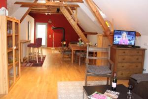 a living room with a dining room table with a tv at Ferienwohnung auf der Rübenburg in Barnsen