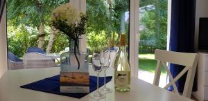 - une table avec un vase avec des fleurs et une bouteille de vin dans l'établissement Reethaus Ostseestrand 15, à Dierhagen