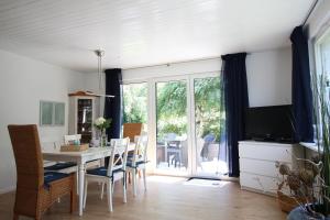 une salle à manger avec une table, des chaises et une télévision dans l'établissement Reethaus Ostseestrand 15, à Dierhagen