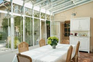 a dining room with a table with a vase of flowers at Depuis la verrière in Bleury