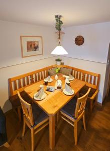 Una mesa de comedor de madera con sillas y una luz. en Heissenhof Urlaub auf dem Bauernhof, en Bernau am Chiemsee