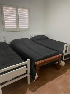 パラナにあるDepto Jose Hernandez tres dormitoriosのベッドルーム1室(ベッド2台、黒いシーツ、窓付)