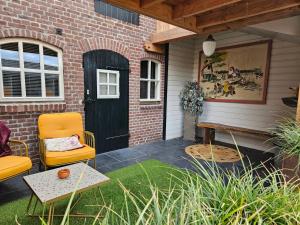 奥斯楚特Bed en Box 3610的门廊设有黑色的门、椅子和桌子