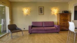 a living room with a purple couch and a chair at 3 pièces 4 étoiles Vue Mer Parking Fibre 500m Palais Festivals in Cannes