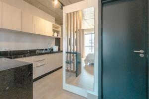a kitchen with a door leading to a bathroom at Excelência, Conforto e Central in Maringá
