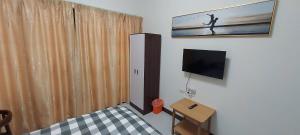 a room with a bed and a television and a table at 大衛城民宿 in Shan-ch'ien