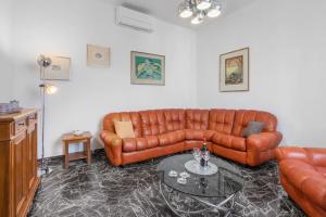 Una sala de estar con un sofá de cuero y una mesa. en Appartamento Diaz In Colle Val D'elsa, en Colle Val D'Elsa