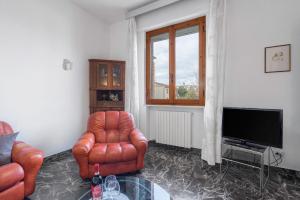 Una sala de estar con dos sillas y un televisor. en Appartamento Diaz In Colle Val D'elsa, en Colle Val D'Elsa