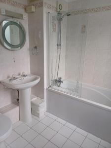 a bathroom with a sink and a shower and a tub at Kings Park Hotel in Glasgow +61 photos