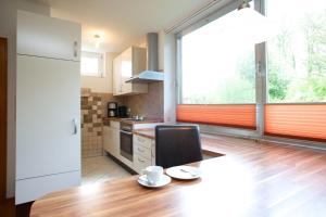 een keuken met een tafel met een stoel en een raam bij Haus am Moorbeek in Eimke