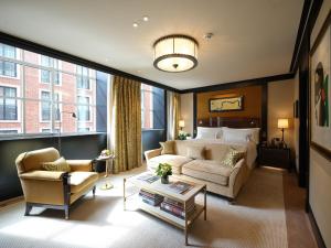 a living room with a bed and a couch at The Beaumont Mayfair in London