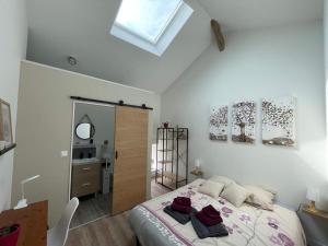 Un dormitorio con una cama grande y una claraboya. en Maison Les Iris - 2 chambres et 2 salles de bain - 2 à 4 personnes - Futuroscope, en Avanton