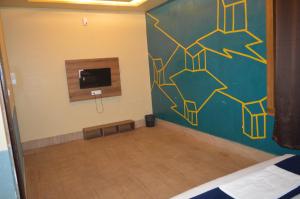 a room with a bed and a wall with a tv at Hotel AshokA in Etah