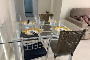 a glass dining room table with two chairs and plates and glasses at Para 10 pessoas, 03 quartos ar condicionado e ventilador, garagem, atrás do hospital da Unimed apt 302 in Petrolina +18 photos