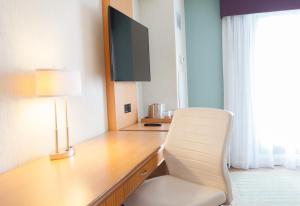 a room with a desk, chair and a lamp at Best Western Premier Toronto Airport Carlingview Hotel in Toronto