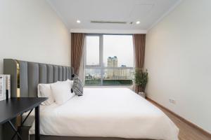 een slaapkamer met een groot wit bed en een raam bij Cozy Nest Vinhomes in Ho Chi Minh-stad +78 foto's