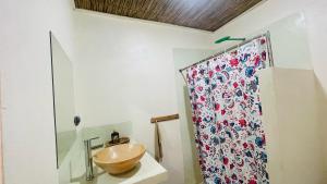 un bagno con lavabo a ciotola e tenda per la doccia di CosyBe Villas a Praia do Tofo