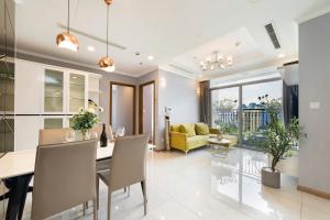een eetkamer en woonkamer met een tafel en stoelen bij Cozy Nest Vinhomes in Ho Chi Minh-stad