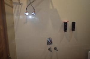 a bathroom with a shower with two lights on the wall at Hotel AshokA in Etah +19 photos