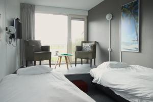 a hotel room with two beds and a table and chairs at Tiny Cottage op Camping "De stal" in Drijber