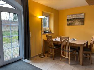 a dining room with a table and chairs and a window at Heidezauber in Bispingen +13 photos
