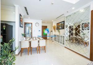 een eetkamer met een tafel en witte stoelen bij Cozy Nest Vinhomes in Ho Chi Minh-stad