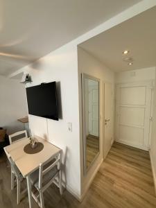 a living room with a table and a television on a wall at Ferienwohnung Centro 2 in Bremerhaven +7 photos