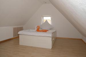 Una cama con un juguete naranja en una habitación en Fewo Kiefer, en Bad Krozingen