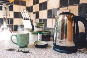 eine Küchentheke mit einem Wasserkocher und einer Tasse in der Unterkunft Wetheral at Wetheral Cottages in Great Salkeld