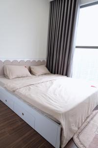 a white bed in a bedroom with a window at Homestay Masteri in Gia Lâm Pho
