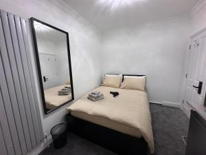a bedroom with a bed with a mirror on the wall at London Bridge Room in London