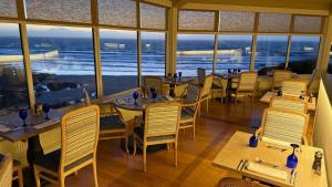 a restaurant with tables and chairs and a view of the ocean at Watersmeet Hotel in Woolacombe