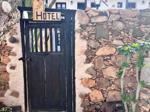 a wooden door with a sign on a stone wall at Casa Rural Isaítas in Pájara