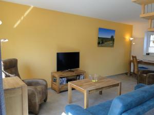 a living room with a flat screen tv and furniture at Heidezauber in Bispingen
