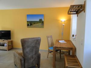 a living room with a table and a chair and a television at Heidezauber in Bispingen