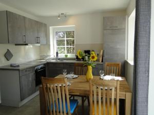 a kitchen with a wooden table with chairs and a vase of flowers at Heidezauber in Bispingen