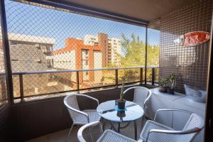 a balcony with a table and chairs and a large window at Paraíso do Atlântico #102D - Estilo por Carpediem in Ilha da Restinga
