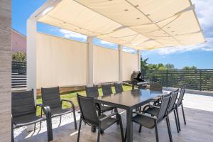 a dining room with a table and chairs at Villa ReMi mit 2 Whirlpools und Meerblick in Premantura