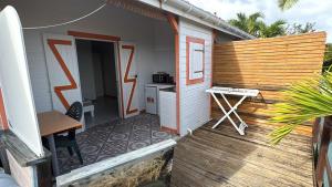 a porch of a house with a table and a desk at Gîtes du Baobab in La Désirade