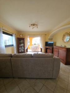 ein Wohnzimmer mit Sofa und Fernseher in der Unterkunft Prestigiosa villa La Cinta in San Teodoro