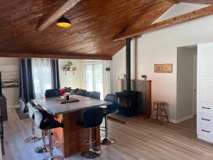 a living room with a wooden table and a fireplace at Cozy chalet near the beach in Shediac +9 photos