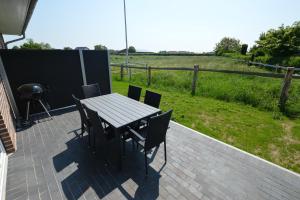 einen Tisch und Stühle auf einer Terrasse mit einem Feld in der Unterkunft Stadthaus 3, inkl 1 Parkplatz in Fehmarn