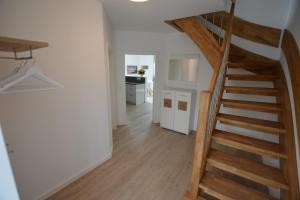 einen Flur mit Holztreppe in einem Haus in der Unterkunft Stadthaus 3, inkl 1 Parkplatz in Fehmarn