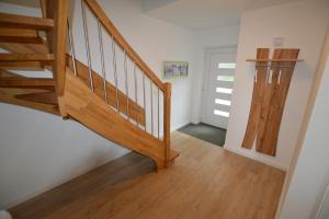 einen Flur mit Holztreppe und Tür in der Unterkunft Stadthaus 3, inkl 1 Parkplatz in Fehmarn