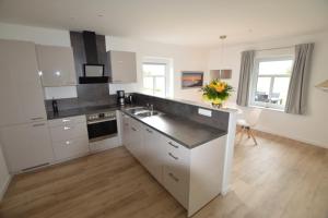 eine Küche mit weißen Schränken und einer Arbeitsplatte in der Unterkunft Stadthaus 3, inkl 1 Parkplatz in Fehmarn