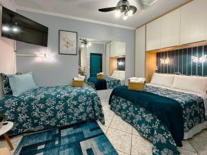 a hotel room with two beds and a mirror at Apartamento Conforto e Prático in Maringá