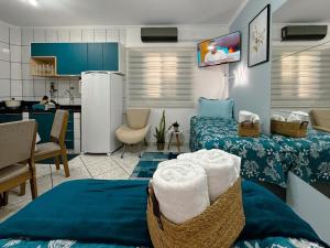 a living room with two beds and a kitchen at Apartamento Conforto e Prático in Maringá