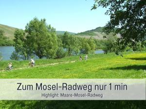 a group of people riding bikes in a field near a lake at Ferienhaus Schwaab-Scherr, genau zwischen Bernkastel-Kues und Traben-Trarbach, mit kostenlosem ÖPNV-Ticket für Bus und Bahn, Parkplätzen und Fahrradgarage in Erden
