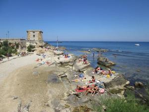 un gruppo di persone sdraiate sulla spiaggia di Le Ninfe Apartment a Trapani